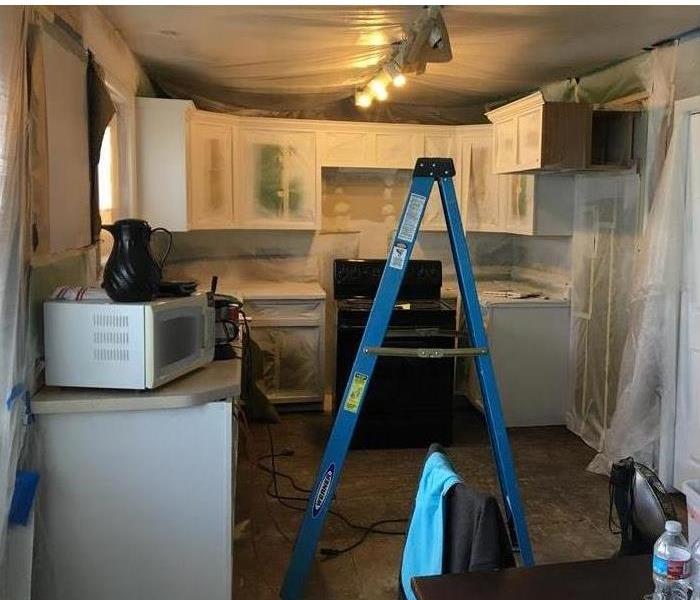 Workers cleaning and restoring fire damaged kitchen 